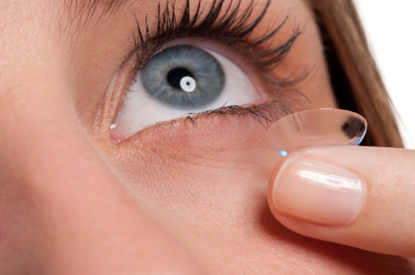 Woman inserting contact lenses